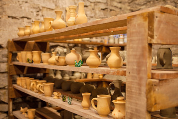 Obraz na płótnie Canvas Pottery dishes on shelves in pottery workshop, editorial photo