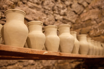 Fototapeta na wymiar Pottery dishes on shelves in pottery workshop, editorial photo