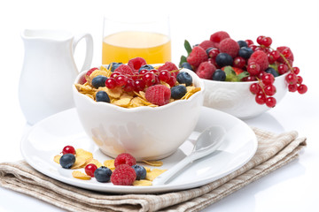 cornflakes with berries, milk and orange juice, close-up