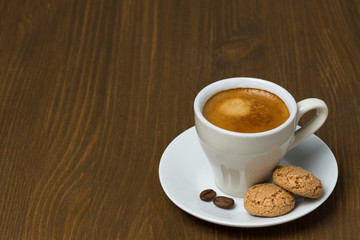 cup of coffee and biscotti on a wooden table and space for text