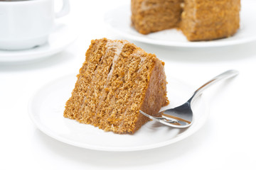 piece of honey cake  and fork on a white plate
