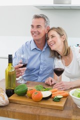 Loving couple with wine glasses in kitchen
