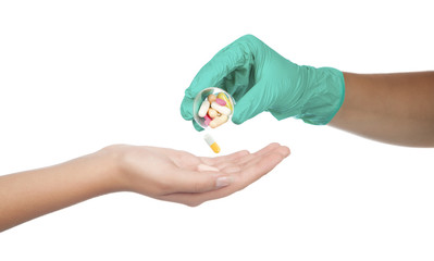 hand giving capsule and pill, on white background