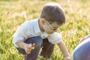Happy cute kid picking flowers in a field