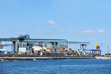 Port cargo crane and container over blue sky background