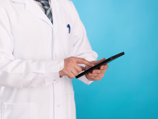Young male doctor with ipad surfing the internet