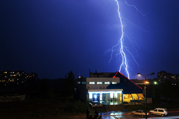 Severe lightning storm over a city buildings
