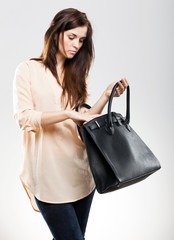 Elegant young woman looking in her bag