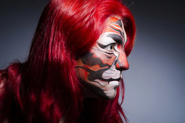 Woman with face painting in dark room