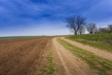 Ploughed field under deep blue sky with clouds