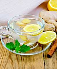 Tea ginger with lemon in a cup on board