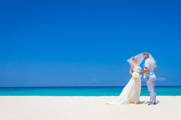 Fototapeta na wymiar young loving couple on wedding day on tropical sand beach