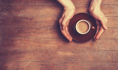 Female hands holding cup of coffee.
