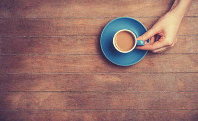 Female hands holding cup of coffee.