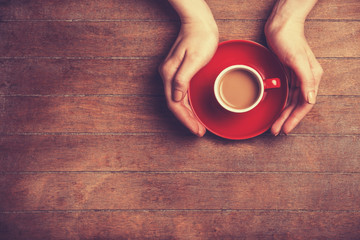 Female hands holding cup of coffee.