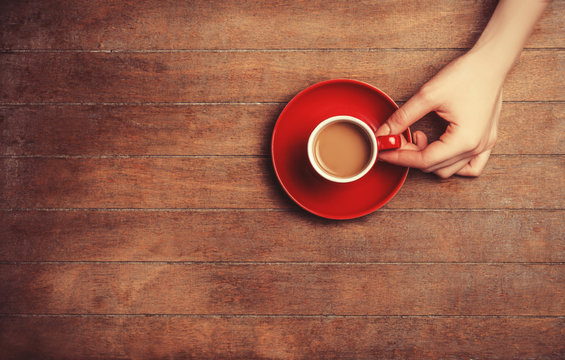 Female hands holding cup of coffee.