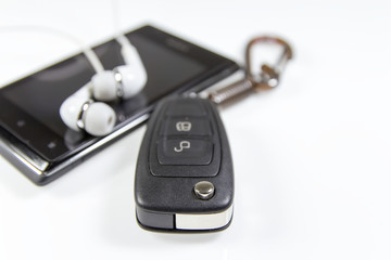 Car keys, phone and headphones isolated on white background