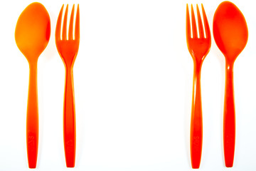 Orange plastic spoon and fork isolated on white background