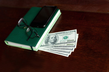 Stacks of one hundred dollars banknotes in notebook