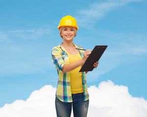 smiling woman in helmet with clipboard