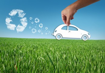 Eco car in the grass, recycle concept, man hand hold a eco car