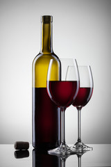 Wine in glasses and bottle on white