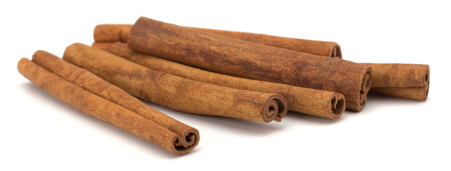 cinnamon sticks stacked on white background