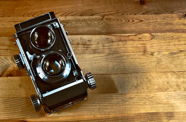 Old vintage camera on a rustic board