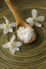 Fototapeta na wymiar White three frangipani and salt in spoon on wooden plate