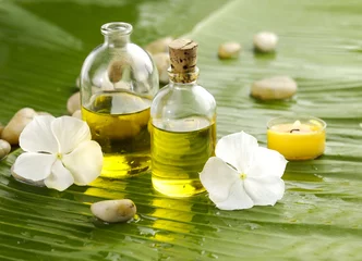 Tuinposter Health spa with massage oil and white flower ,candle on leaf © Mee Ting