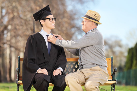 Father Preparing His Son For Graduation In Park