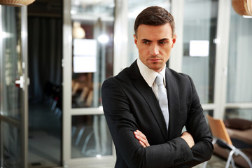 Pensive businessman standing at office