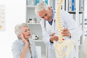 Fototapeta premium Male doctor explaining the spine to senior patient