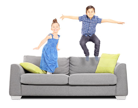 Boy And A Girl Jumping On The Couch