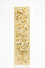 Handmade white chocolate bar with almonds on white background