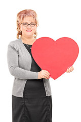 Mature lady holding a big red heart posing