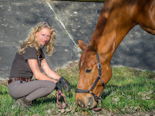 Frau versorgt ihr Pferd 