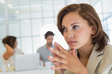 Close-up of a serious businesswoman with colleagues in meeting