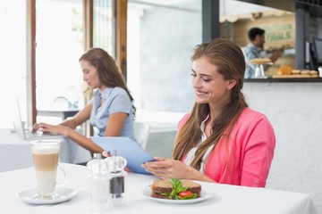 Woman using digital tablet in coffee shop