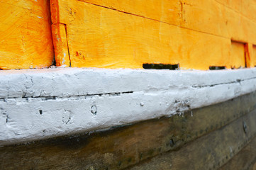 A close up veiw of the paint on a wooden boat.