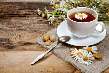 herbal tea with chamomile on old wooden table
