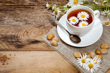 herbal tea with chamomile on old wooden table
