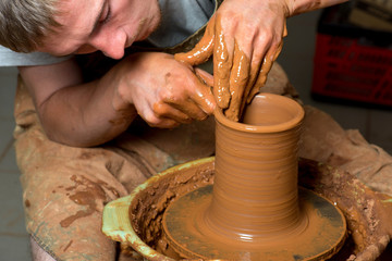 hands of a potter, creating an earthen jar