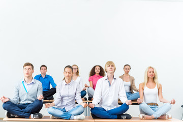 group of young people meditating