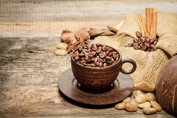 Wooden cup with coffee-beans on wooden table