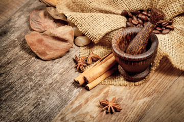 Cinnamon, star anise and coffee beans on old wooden table