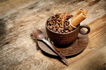 Wooden cup with coffee-beans on wooden table