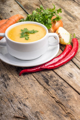 Organic food. Pea soup with vegetables around on wood background