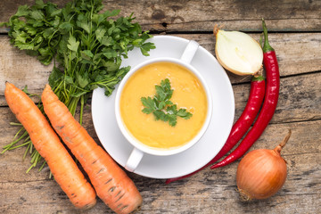 Organic food. Pea soup with vegetables around on wood background