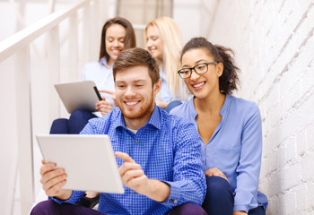 team with tablet pc computer sitting on staircase